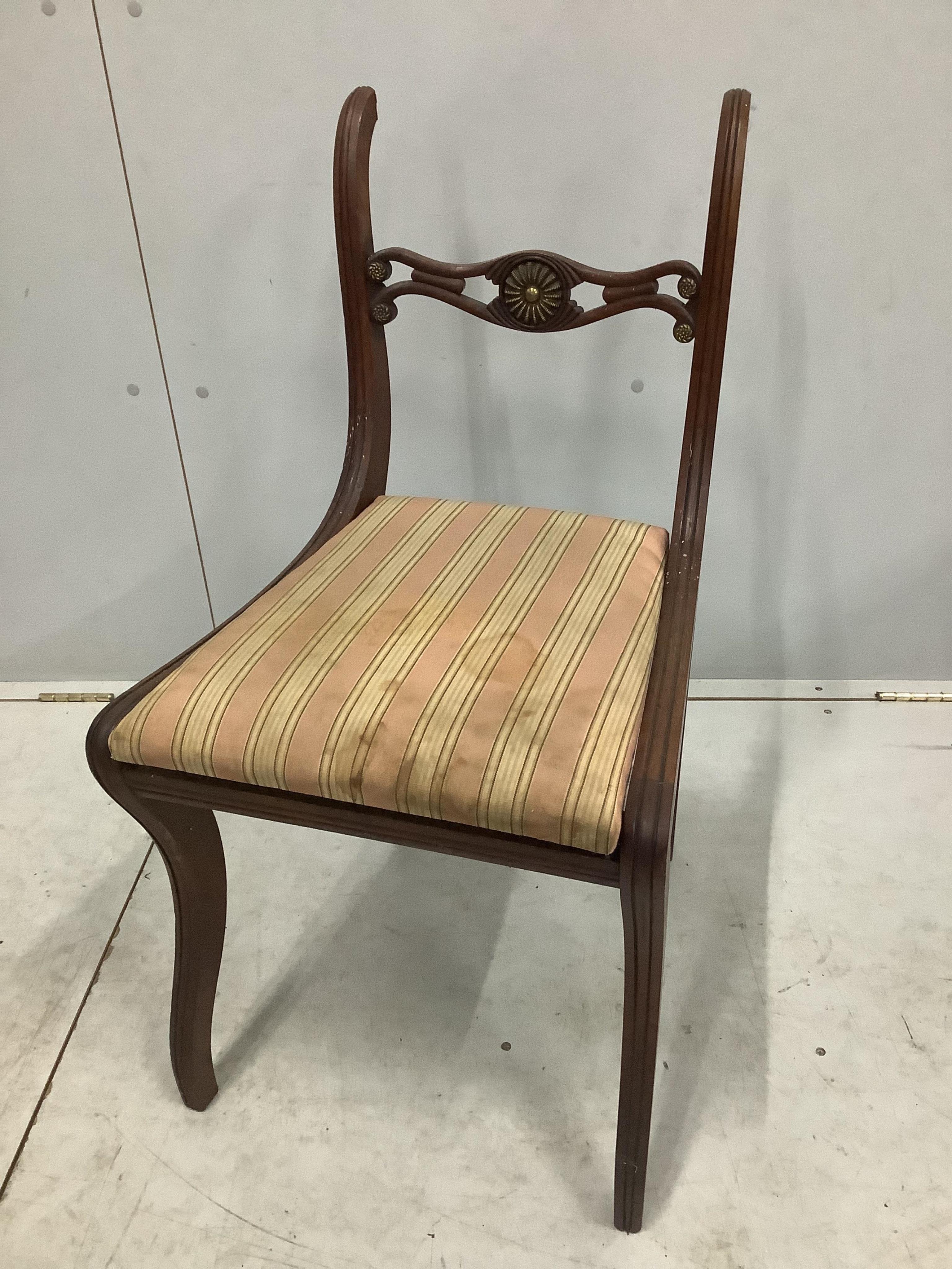 A set of eight Regency brass mounted mahogany dining chairs, one with arms. Condition - poor to fair, one lacking top rail